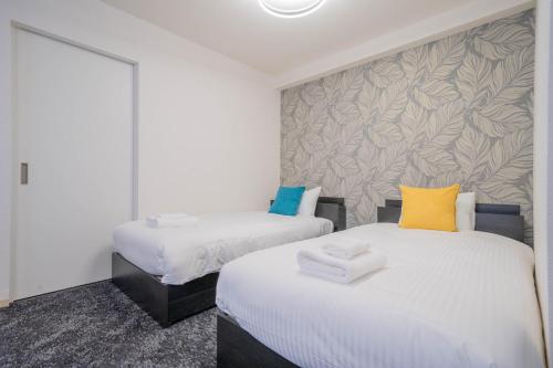 two beds with towels on them in a room at MP STYLE SAPPORO-35 in Minami-jūichijō