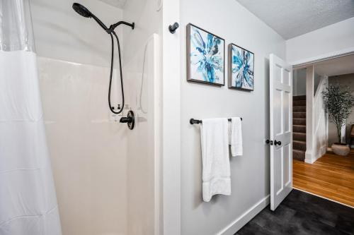 a bathroom with a shower and white towels at Serenity Shores 5BD Hot Tub Fishing Hiking in Traverse City