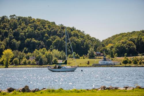 a boat floating on a lake with a mountain at Serenity Shores 5BD Hot Tub Fishing Hiking in Traverse City