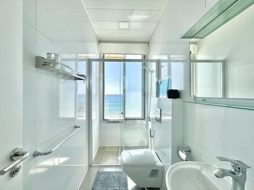 Un baño blanco con lavabo e inodoro. en Shatt El Reewa Villa, en Fad‘ūs