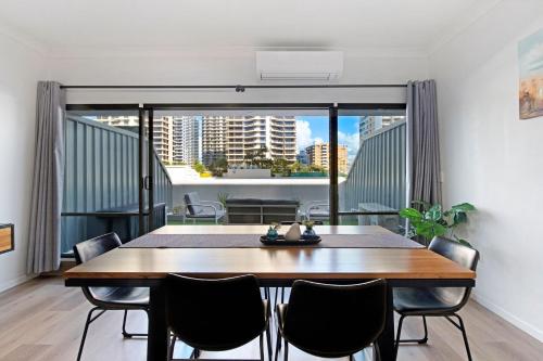 a dining room with a table and chairs and a balcony at Unbeatable Location - Spacious 3 bedroom townhouse in Gold Coast