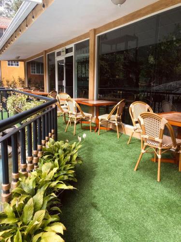a patio with chairs and a table with grass at Hostería y Centro de Convenciones Baguanchi in Cuenca