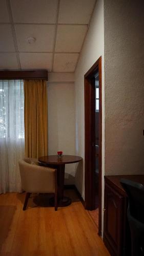 a living room with a table and a chair at Hostería y Centro de Convenciones Baguanchi in Cuenca