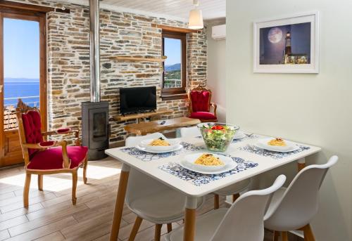 a dining room with a table and chairs and a fireplace at Vista Mare in Afissos