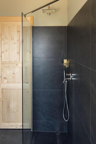 a bathroom with a shower with a glass door at PODERE DELL'ETNA SEGRETA - Essential Nature Hotel & Glamping in Biancavilla