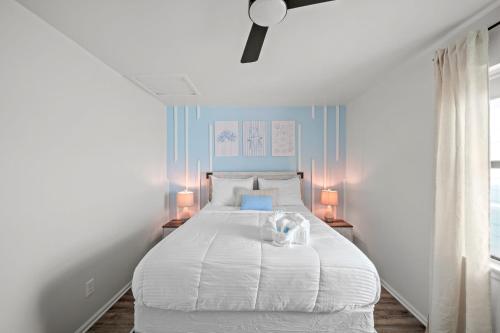 a bedroom with a large white bed with two lamps at Vitamin Sea in Gulf Shores