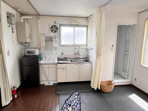 a small kitchen with a sink and a refrigerator at Iris in Hakodate