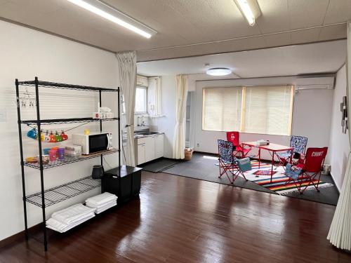 a living room with a table and chairs and a kitchen at Iris in Hakodate
