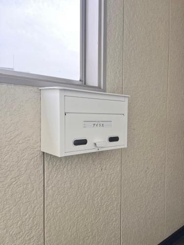 a white box on a wall under a window at Iris in Hakodate