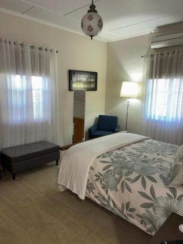 a bedroom with a bed and a blue chair at Hideaway on Hume in Boonah