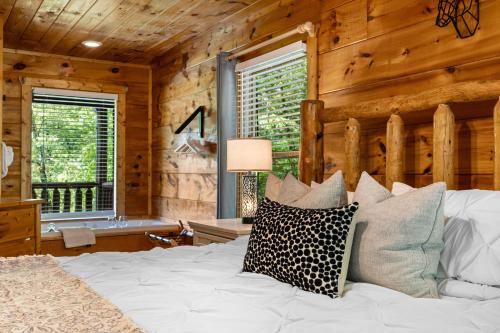 a bedroom with a white bed with wooden walls at Serenity Escape in Sevierville