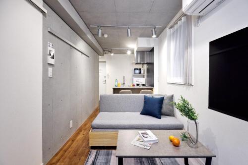 a living room with a couch and a table at Apiche Oji in Tokyo