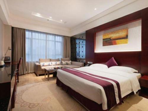 a hotel room with a large bed and a couch at Fuzhou Xin Zi Yang Hotel in Fuzhou
