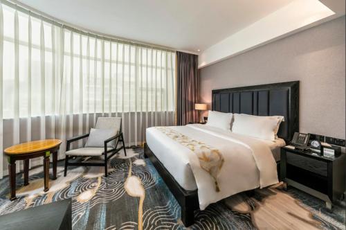 a hotel room with a bed and a table and a chair at Fuzhou Xin Zi Yang Hotel in Fuzhou