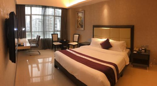 a bedroom with a large bed and a desk and chairs at Fuzhou Xin Zi Yang Hotel in Fuzhou