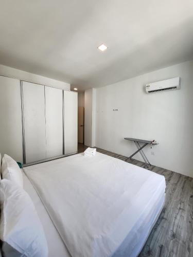 an empty room with a large white bed in it at Zen66 @ Roxy Serviced Apartment in Kuching
