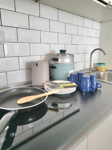 a kitchen counter with plates and utensils on a stove at Zen66 @ Roxy Serviced Apartment in Kuching