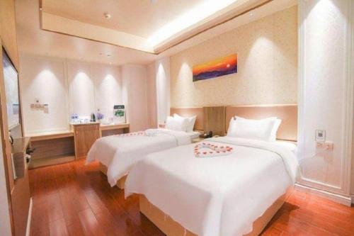 two beds in a hotel room with white sheets at Quanzhou Binhai Hotel in Quanzhou