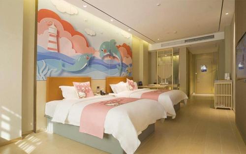 a bedroom with two beds and a painting on the wall at Quanzhou Binhai Hotel in Quanzhou
