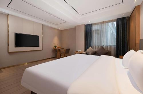 a hotel room with a large bed and a television at Quanzhou Binhai Hotel in Quanzhou