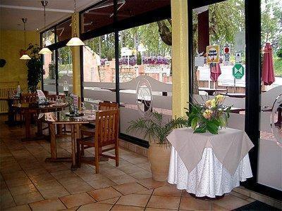 a restaurant with tables and chairs and a table with flowers at Hôtel La Renaissance in Revel