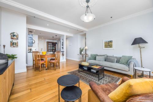a living room with a couch and a table at Central Apt with Art Gallery Views and FREE Parking in Auckland