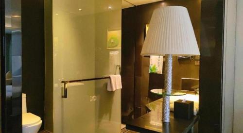 a room with a lamp and a bathroom with a toilet at Yongzhou Chuang Fa Cheng XiaoXiangYi Hotel in Guzhuting