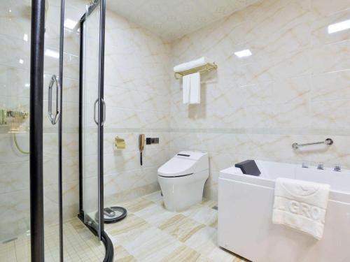 a bathroom with a shower and a toilet and a tub at Wanjiale International Hotel in Changsha