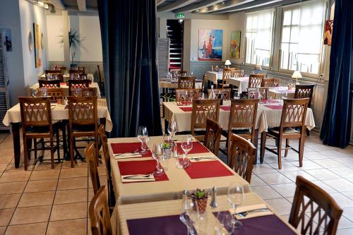 un comedor con mesas y sillas y un restaurante en Le Lion d'Or, en Ingrandes