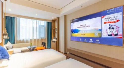a bedroom with a large screen on the wall at East Queen Hotel (Xi'an Beimen Metro Station) in Xi'an