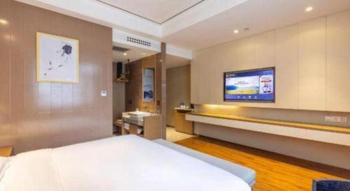 a bedroom with a bed and a flat screen tv at East Queen Hotel (Xi'an Beimen Metro Station) in Xi'an