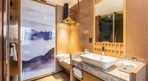 a bathroom with a sink and a large mirror at East Queen Hotel (Xi'an Beimen Metro Station) in Xi'an