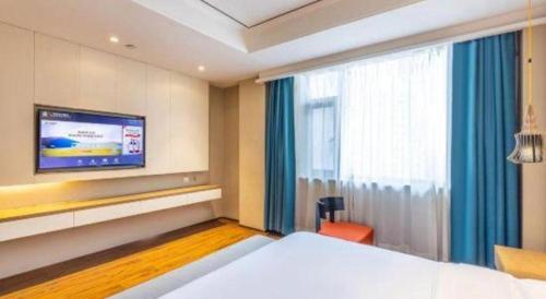 a hotel room with a bed and a tv at East Queen Hotel (Xi'an Beimen Metro Station) in Xi'an