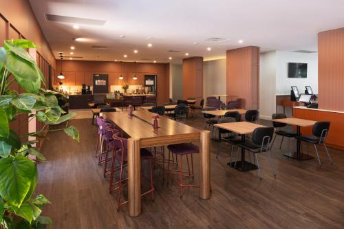 a restaurant with tables and stools in a room at Mercure Newcastle in Newcastle
