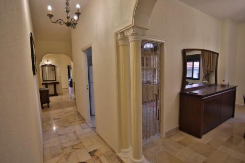 a living room with a hallway with a chandelier at 3BR in Batroun Bahsa Old Souks in Batroûn