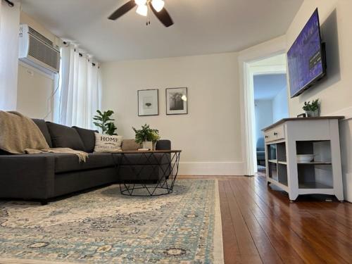 a living room with a couch and a tv at Historic Ludlow Apt B in Ludlow