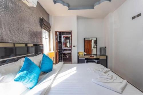 a bedroom with a large white bed with blue pillows at Karon Sunset Seaview Villa by 789property in Karon Beach