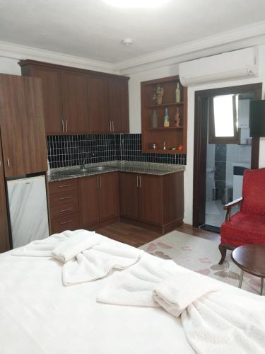 a bedroom with a white bed and a red chair at Jasmin Apart Otel in Göcek