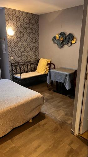 a room with two beds and a table and a bench at La Chaumiere d Agde in Agde