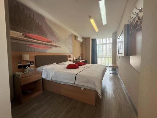 une chambre avec un lit avec des oreillers rouges dessus dans l'établissement Thank Inn Hotel Shandong Heze Mudan District Bayi Road Pedestrian Street, à Zhaolou