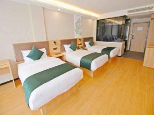 a hotel room with two beds in a room at GreenTree Inn Express Zhangjiagang Hexing Town Shazhou Professional Institue of Technology in Qiwei