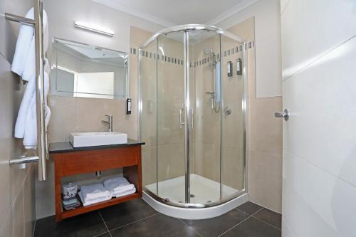 a bathroom with a shower and a sink at City Corporate Motor Inn in Palmerston North