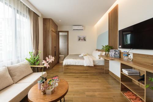 a living room with a couch and a tv and a bed at Crescendo Limitless Style in Hanoi