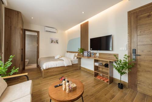 a living room with a bed and a table at Crescendo Limitless Style in Hanoi