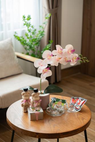 a coffee table with a vase of flowers on it at Crescendo Limitless Style in Hanoi