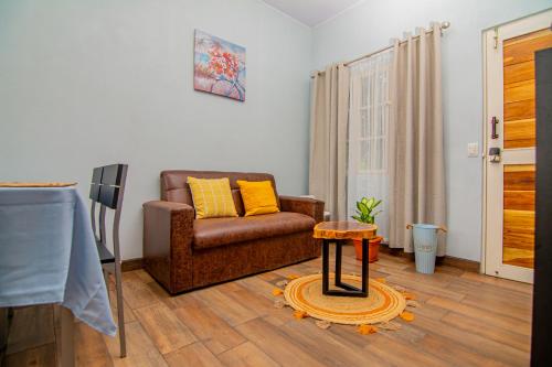 a living room with a couch and a table at Villas Mali La Fortuna in Guayabal