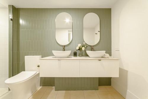 a bathroom with two mirrors and a sink and a toilet at Lux 18th floor 2br 2bath, River view, Pool, Spa, Sauna, Gym, Wifi, in Brisbane