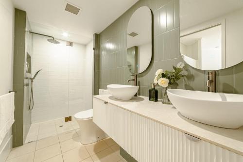 a bathroom with a sink and a toilet and a mirror at Lux 18th floor 2br 2bath, River view, Pool, Spa, Sauna, Gym, Wifi, in Brisbane