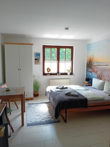 a bedroom with a large bed and a desk at Ostwind - ferienwohnungen & meer in Steffenshagen