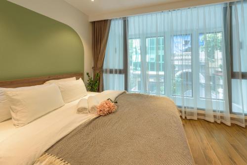 a bedroom with a large bed with a large window at Crescendo Limitless Style in Hanoi